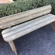 Traditional long wooden park bench with rounded edges in public gardens