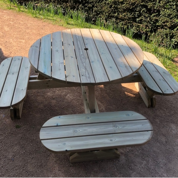 Round timber picnic table with round seats and umbrella hole